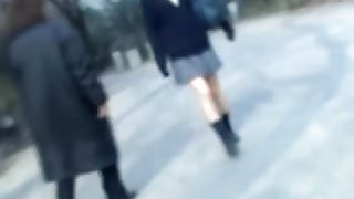 Naughty man sharking Asian college girl skirt in the street